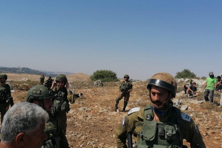 חיילים באדמות הכפר בתיר אחרי שהוזעקו בידי תושבי הכפר. המתנחל ליאור פז בחולצה הירוקה מימין (צילום: ע'סאן עליאן)