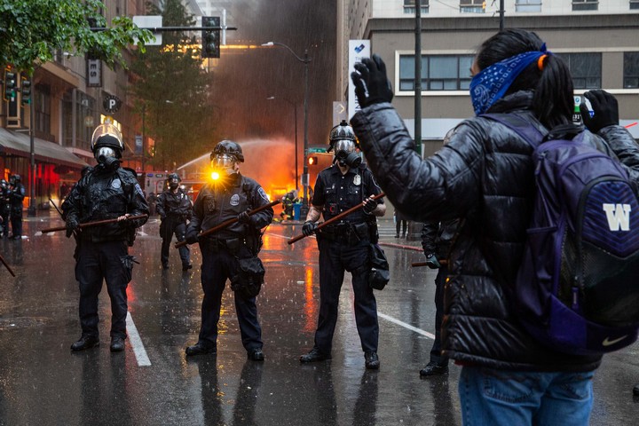 המטרה היא לאפשר למפגינים למחות בראש שקט. מפגינה מול שוטרים בסיאטל (צילום: קלי קליין CC BY NC ND 2.0)