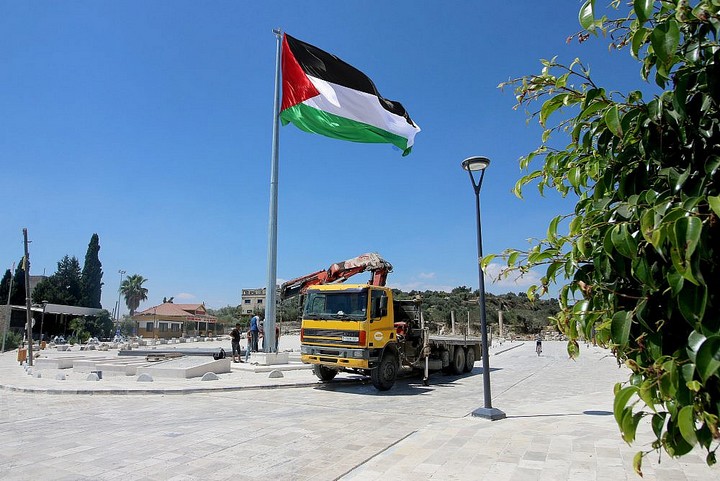 "אסור לנו להזיז אבן באתר בלי אישור ישראלי, לכן בנינו את הכיכר בשטח בי". מנוף מסיר את התורן עם הדגל הפלסטיני (צילום: אחמד אל-באז / אקטיבסטילס)