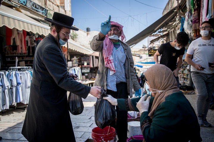 חרדי קונה מפלסטינית בעיר העתיקה בירושלים, ב-17 באוגוסט 2020 (צילום: יונתן זינדל / פלאש90)