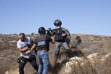 עיתונאים ושוטר מג״ב במסיק זיתים בכפר בורקא (צילום: מיה אויס)