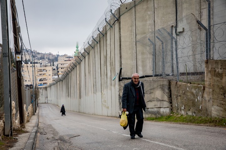 פלסטיני הולך ליד גדר ההפרדה באבו דיס, ב-2 בפברואר 2020 (צילום: אוליבייה פיטוסי / פלאש909