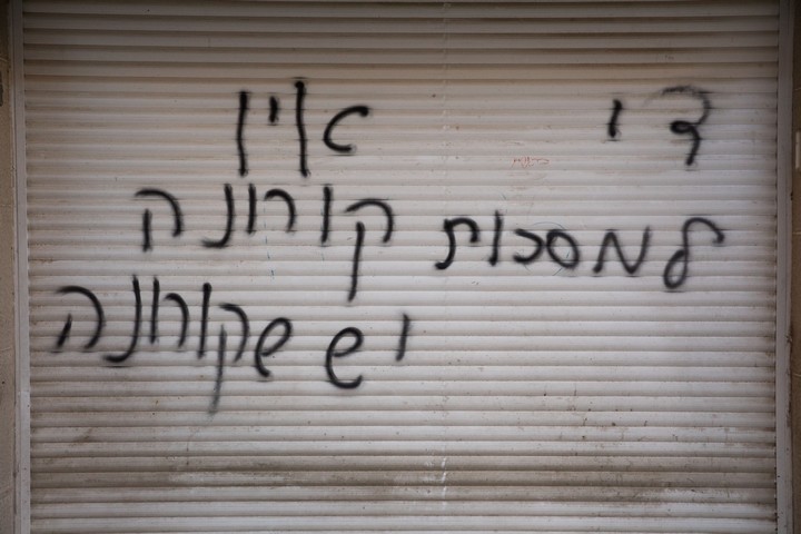 שהחולים ידאגו לעצמם. כתובת קיר נגד החובה לעטות מסכות (נתי שוחט / פלאש 90)