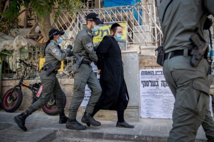 שוטרים עוצרים חרדי בפשיטה על בית כנסת בשכונת גאולה בירושלים שנפתח בניגוד לתקנות הקורונה, ב-14 באוקטובר 2020 (צילום: יונתן זינדל / פלאש90)