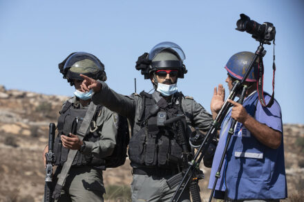 עיתונאי ושוטר מג״ב במסיק זיתים בכפר בורקא (צילום: אורן זיו)