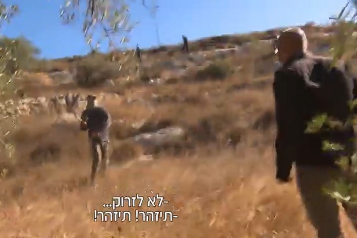 אוהד חמו מותקף על ידי מתנחל רעול פנים באדמות כפר בורקא (צילום מסך מערוץ 12)