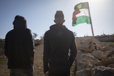 בנקודה שבה עלי אבו עליא נורה למוות מתנוסס דגל פלסטין. באסם ואחמד, אחיו וחברו של עלי, ליד מקום הירי באל-מוע'ייר (צילום: אורן זיו)
