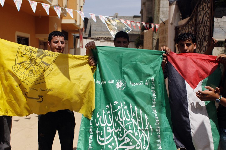 מפגינים פלסטינים מניפים דגלי פת"ח, חמאס ודגל פלסטין בתמיכה בפיוס לאומי, בחאן יונס ברצועת עזה, ב-29 במאי 2014 (צילום: עבד רחים חטיב / פלאש90)