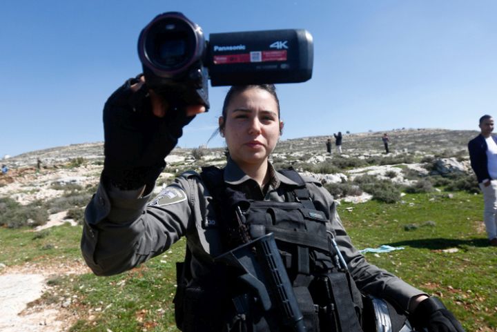 האזרחים לא יודעים שהידיעה שהם קוראים עברו צזנורה. חיית מג"ב מצלמת צלם פלסטיני בחברון (צילום: ויסם השלאמון / פלאש 90)