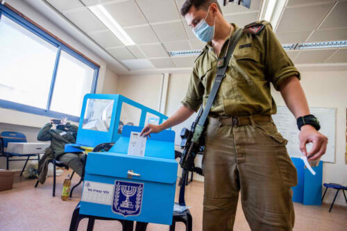 חמישה חיילים שמחליטים לא להעביר פלסטיני במחסום זו לא דמוקרטיה. חייל מצביע בקלפי בבסיס צבאי בהצבעה מוקדמת בבחירות במארס 2012 (צילום: פלאש 90)