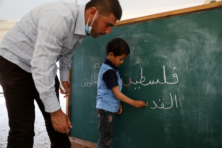 הפלסטינים רוצים קודם כל לתקן את העוול. ילד פלסטיני כותב "פלסטין" על הלוח (צילום: ויסאם השלאמון / פלאש 90)