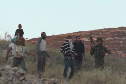 מתנחל רעול פנים מיידה אבן לעבר תושבי בורין, חייל עומד מנגד: תיעוד מתוך התקיפה בבורין (צילום: מוניר קאדוס, יש דין)