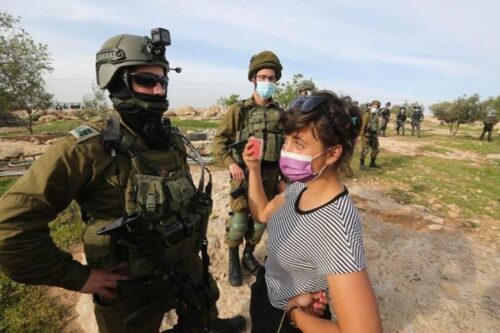 "אנחנו, כישראלים, שולטים בחיים של תושבי מסאפר יטא, לכן אני מרגישה אחריות". נעמי-נור צחור מול חיילים במסאפר יטא (צילום: באסל אל עדרה)