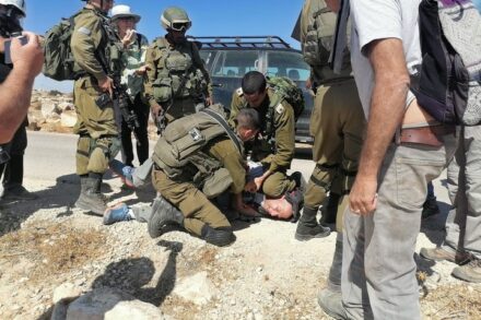 אם כך הצבא מתנהג לישראלים בעלי זכויות, כיצד הוא נוהג לתושבים הפלסטינים נטולי הזכויות, נעדרי ייצוג פוליטי? תולי פלינט מתחת לברך של הקצין (צילום: אוסאמה אלוואט)