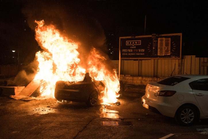הצתת מכונית במהלך ההתנגשויות בעכו במאי השנה. לעירייה לא ידוע על מתח בין הגרעין התורני לתושבים הערבים (צילום: רוני עופר / פלאש 90)