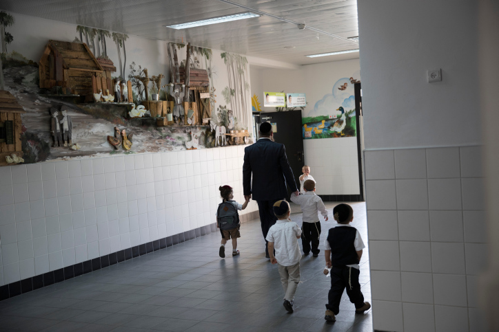 הטיפול בילדים נופל במידה רבה עם הגברים. גבר חרדי מביא את ילדיו לתלמוד תורה בביתר עלית (צילום: נתי שוחט / פלאש 90)