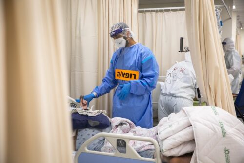 רופא מטפל בחולה במחלקת קורונה (צילום: אוליבייה פיטוסי / פלאש90)