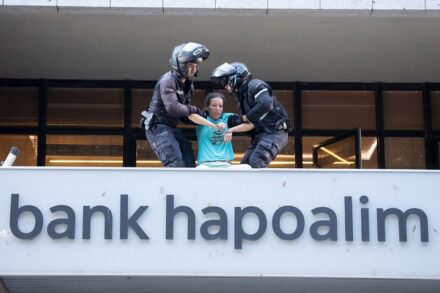 שוטרים עוצרים פעילה של המרד בהכחדה בזמן מחאה מחוץ למשרדי בנק הפועלים בתל אביב, ב-6 באוקטובר 2021 (צילום: אורן זיו)