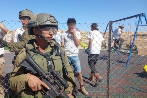 מתנחלים פולשים לגן משחקים בסוסיא, בליווי הצבא, ב-6 בנובמבר 2021 (צילום: אחמד נאסר)