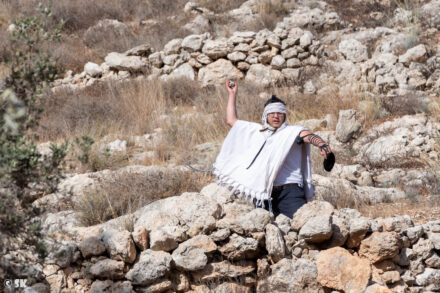 מתנחל מיידה אבנים לעבר חקלאים ופעילים ישראלים בעיירה צוריף (צילום: שי קנדלר)