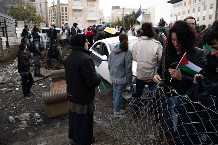 פאטמה סאלם מצידה האחד של הגדר בעוד המפגינים מעברה השני על דרך קונד'ר, ב-17 בדצמבר 2021 (צילום: מתן גולן)