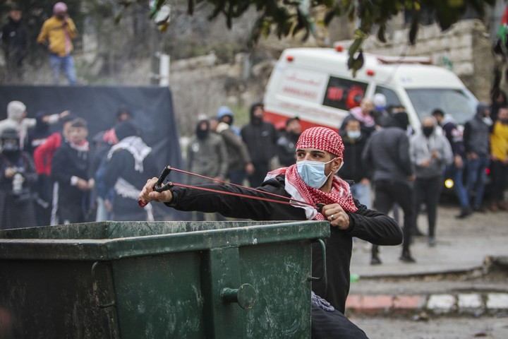פלסטינים מפגינים מול חיילים בבורקה, ב-23 בדצמבר 2021 (צילום: נאסר אישתיה / פלאש90)