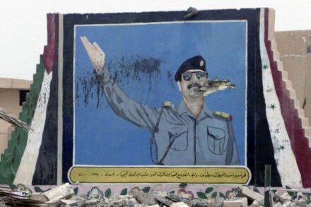 תמונה של סדאם חוסיין שנפגעה בזמן המלחמה, לצד דרך בעיראק (צילום: הארכיונים הלאומיים של ארה"ב)