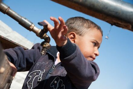 המים מגיעים רק כל יום שלישי. ילד פלסטיני ליד מיכלית מים בדרום הר חברון (צילום: ריאן רודריק ביילר / אקטיבסטילס)