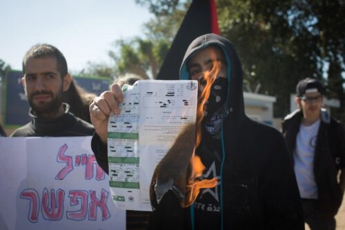 יותר מ-83% מהצעירים שפנו לוועדה לא שירתו בצבא בסופו של דבר. מפגין שורף צו גיוס מחוץ לבקו״ם, במהלך הפגנת הזדהות עם הסרבניות תאיר קמינר וטניה גולן, ינואר 2016 (צילום: אורן זיו)