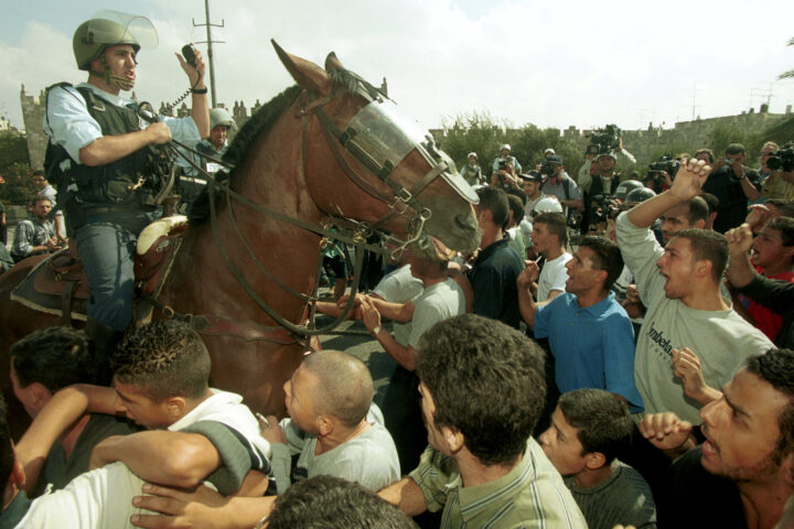 שוטר מול מפגינים ערבים, באוקטובר 2000 (צילום: פלאש90)