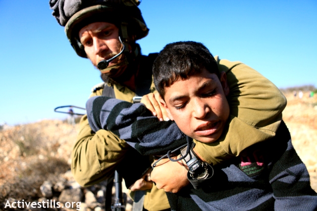 ישראל מפרה את האמנה להגנה על ילדים שהיא חתונה עליה. חייל עוצר ילד בבית אומר ב-2011 (צילום: אן פאק / אקטיבסטילס) מפרים את זכויות היסוד של 
