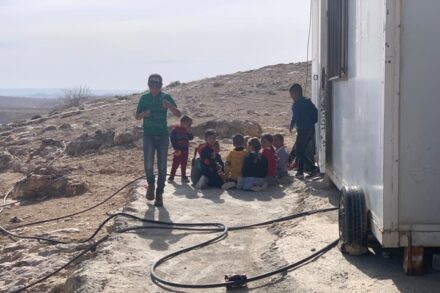 התלמידים ליד הקרוואן שמשמש להם בית ספר בח'ירבת א-ספאיי (צילום: באסל אל עדרה)