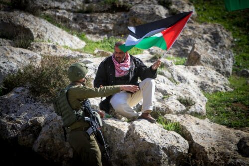 מנהיגי ההתנגדות הלא-אלימה לא נושאים ונותנים, לא מוותרים, ולא מחזיקים בתעודות VIP. חייל מול מפגין פלסטיני בכפר בית דג'אן, 27 בינואר 2023 (נאסר שתייה / פלאש 90)