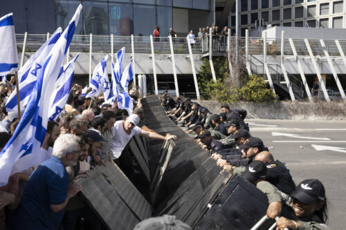 מפגינים פורצים מחסום משטרתי בדרך לאיילון, במהלך ״יום שיבוש״ בתל אביב, 1 במרץ 2023