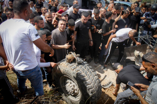 ההתקפות מן האוויר חושפות שלב מסוכן באבולוציה של הכיבוש. פלסטינים מתרכזים סביב חלקי רכב צבאי משוריין, בג'נין, 19 ביוני, 2023 (צילום: נאסר אישתיה / פלאש 90)