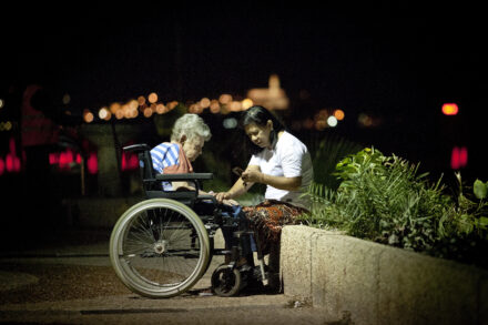 עובדת סיעוד פיליפינית וקשישה בטיילת בתל אביב (צילום: משה שי / פלאש90)