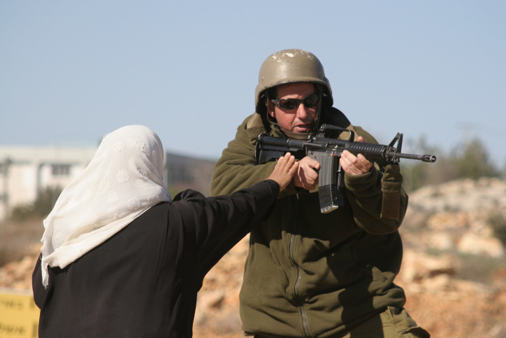 נחלצו להגן על האדמות שלהם. פלסטינית מול חייל באדמות הכפר איסגאגא (צילום: פלאש 90)