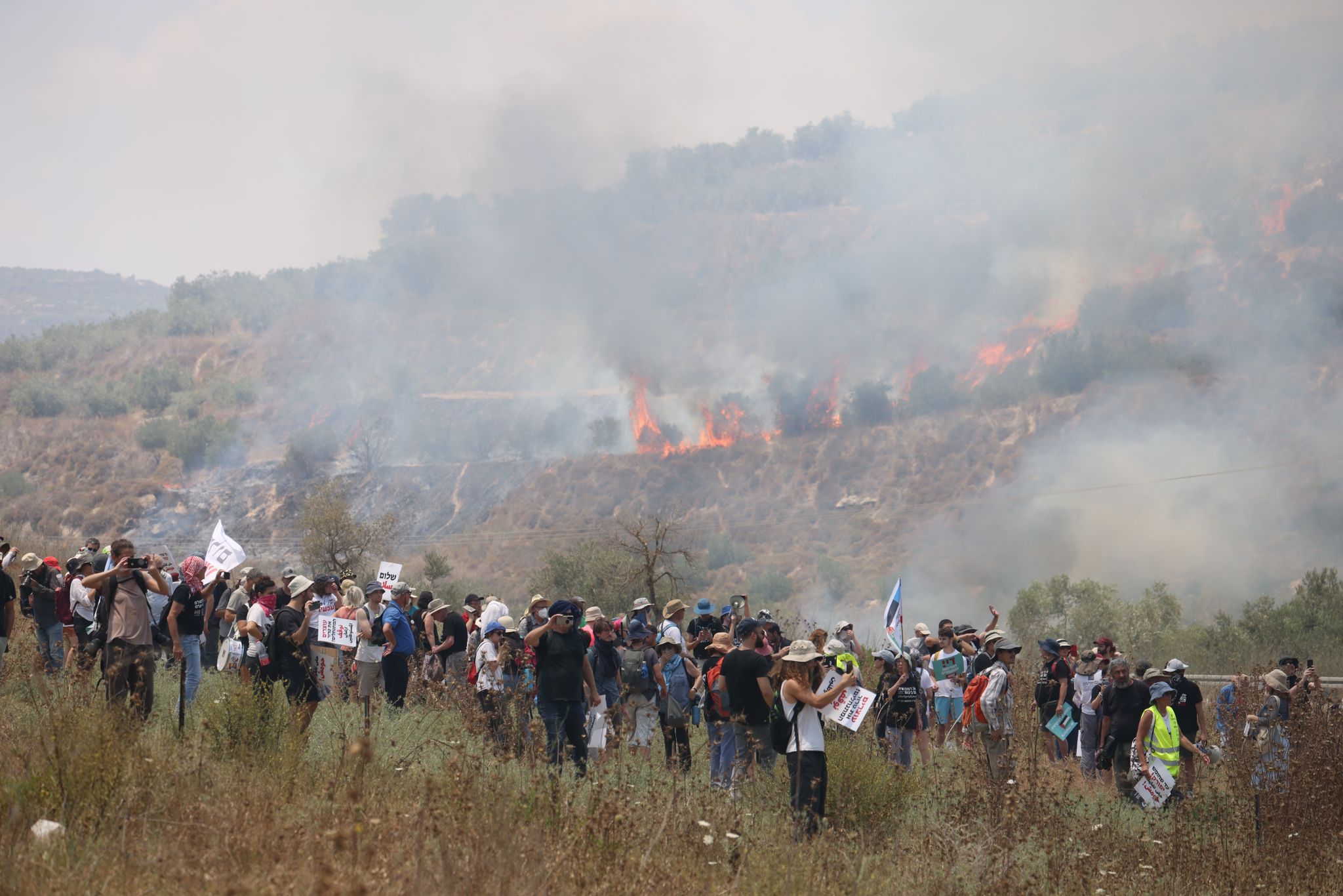 פעילי שמאל על רקע שריפה שהחלה בעקבות ירי גז מדמיע במהלך צעדת מחאה לחומש, 7 ביולי 2023 (צילום: אורן זיו)