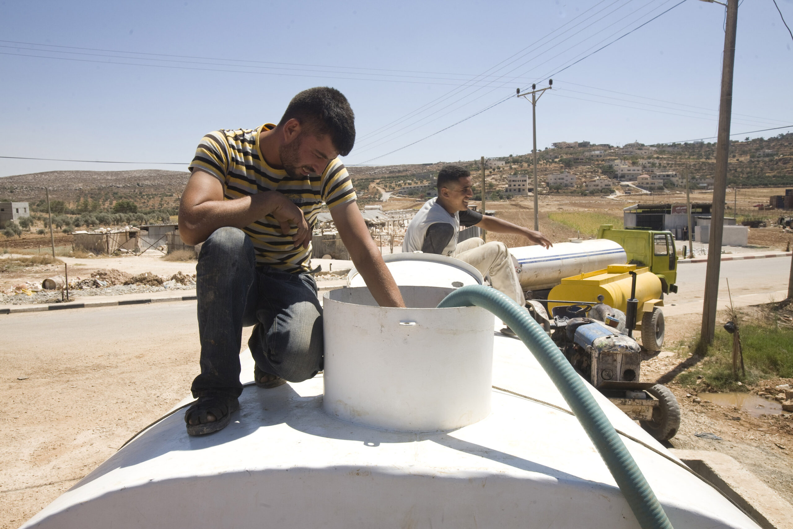 פרויקטים פלסטיניים לא מקבלים אישור. פלסטינים ממלאים מים במכלית ליד שכם, 2009 (צילום: אקטיבסטילס)