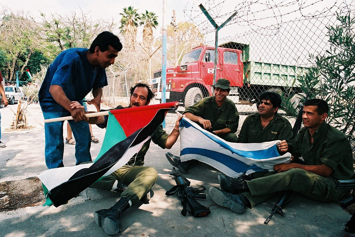 שוטרים פלסטינים חוגגים את כניסתם ליריחו לצד חיילים ישראלים, ב-13 במאי 1994 (צילום: יוסי זמיר / פלאש90)