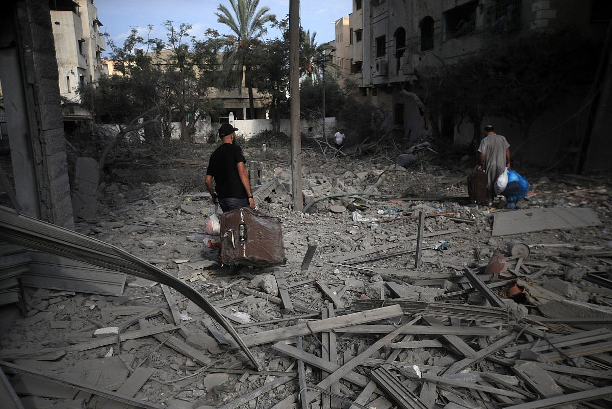 פלסטינים הולכים בין הריסות שכונת א-רימאל בעיר עזה, בעקבות ההפצצות הישראליות, ב-10 באוקטובר 2023 (צילום: מוחמד זענון)