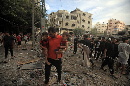 פלסטינים בין הריסות בניין אחרי הפצצה ישראלית בעיר עזה, ב-7 באוקטובר 2023 (צילום: מוחמד זענון / אקטיבסטילס)