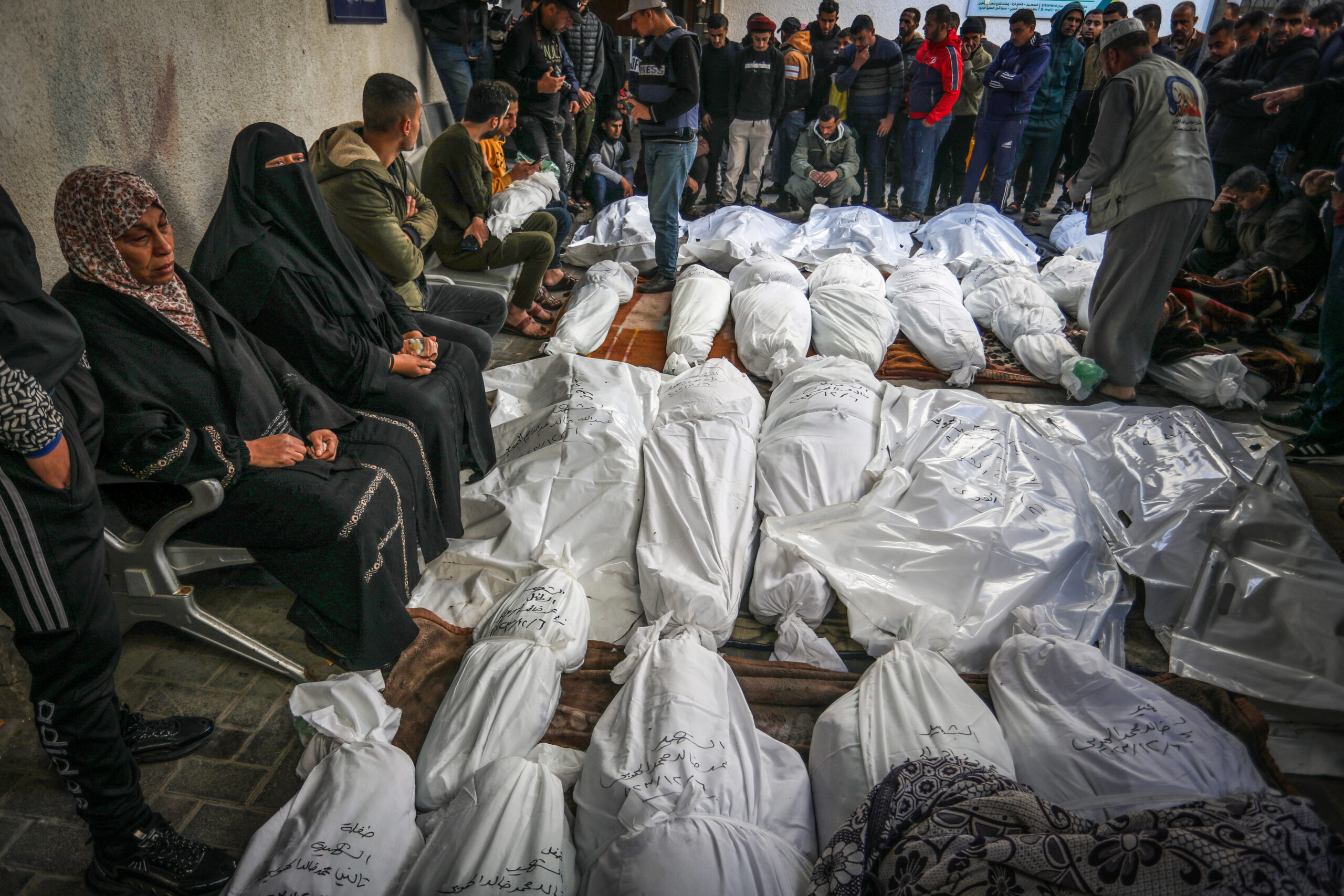 יותר מ-8000 ילדים הרוגים. פלסטינים מחכים לקבל את גופות בני משפחותיהם בבית חולים בח'אן יונס, דצמבר 2023 (צילום: עבד רחים ח'טיב / פלאש 90)
