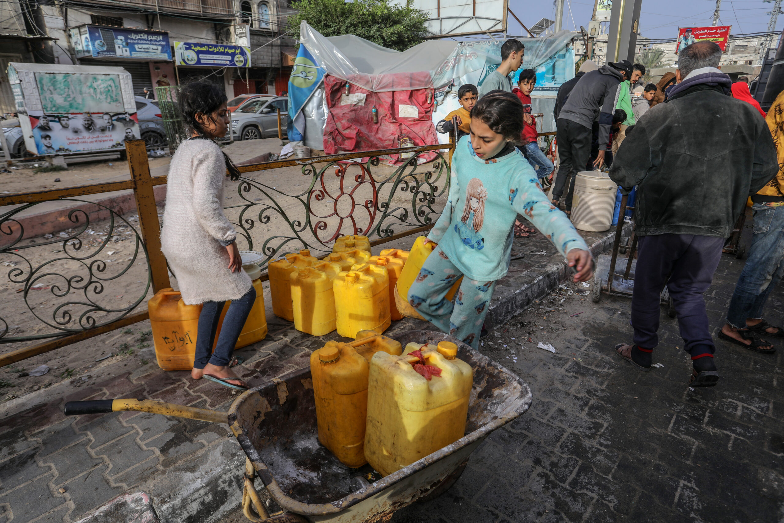 פלסטינים בחלוקת מים לשתייה ברפיח, ב-23 בדצמבר 2023 (צילום: עבד רחים ח'טיב / פלאש90)