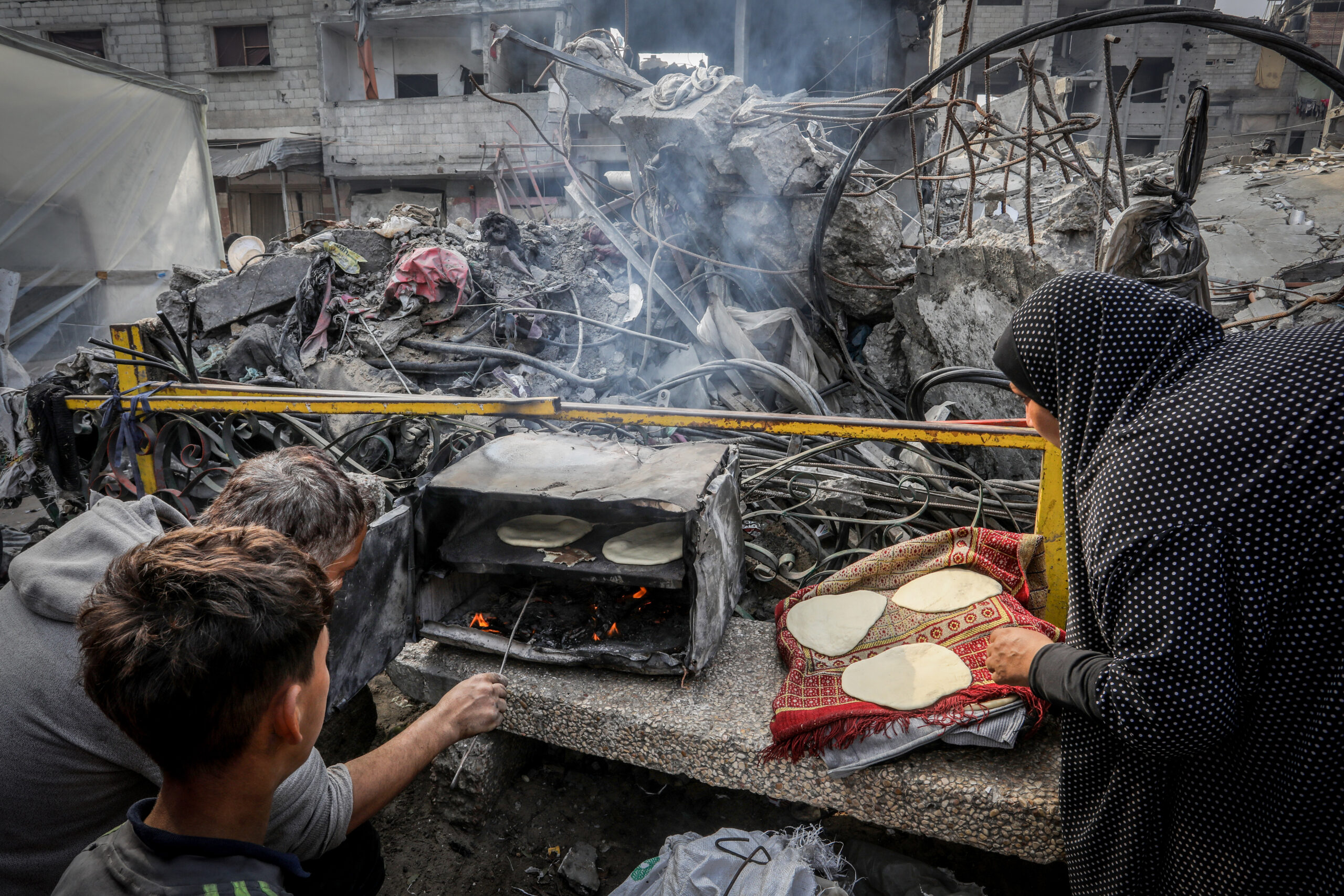 פלסטינים מכינים לחם ברחוב ברפיח, ב-28 בדצמבר 2023 (צילום: עבד רחים ח'טיב / פלאש90)