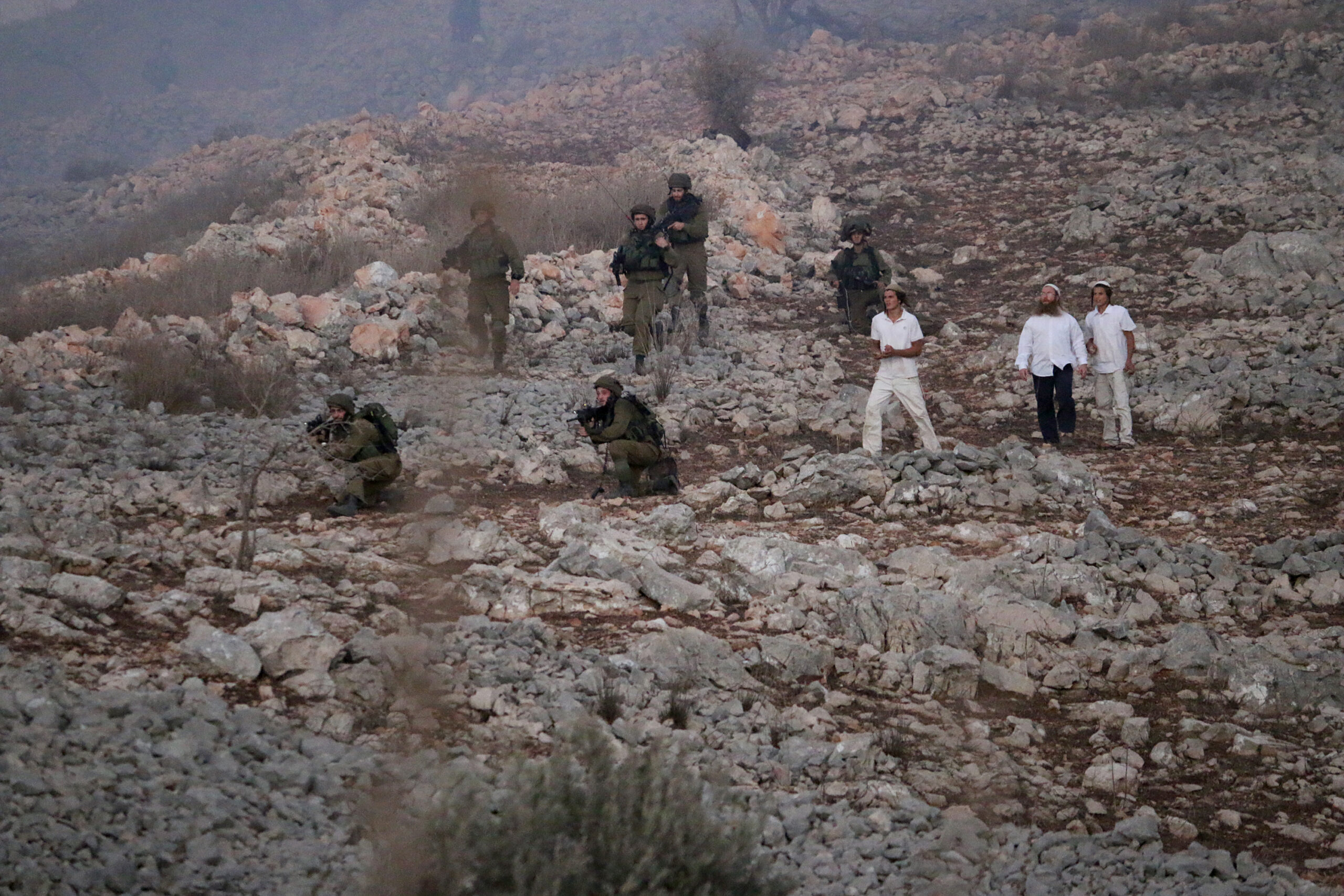 מתנחלים וחיילים ליד הכפר בורין בגדה המערבית, ב-2015 (צילום: אחמד אל באז / אקטיבסטילס)