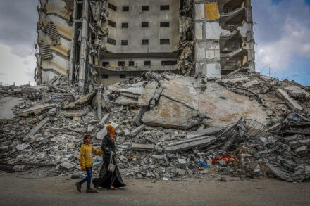 פלסטינים ליד בניין שנהרס בהפצצה ישראלית ברפיח, בדרום רצועת עזה, ב-18 במרץ 2024 (צילום: עבד רחים ח'טיב / פלאש90)