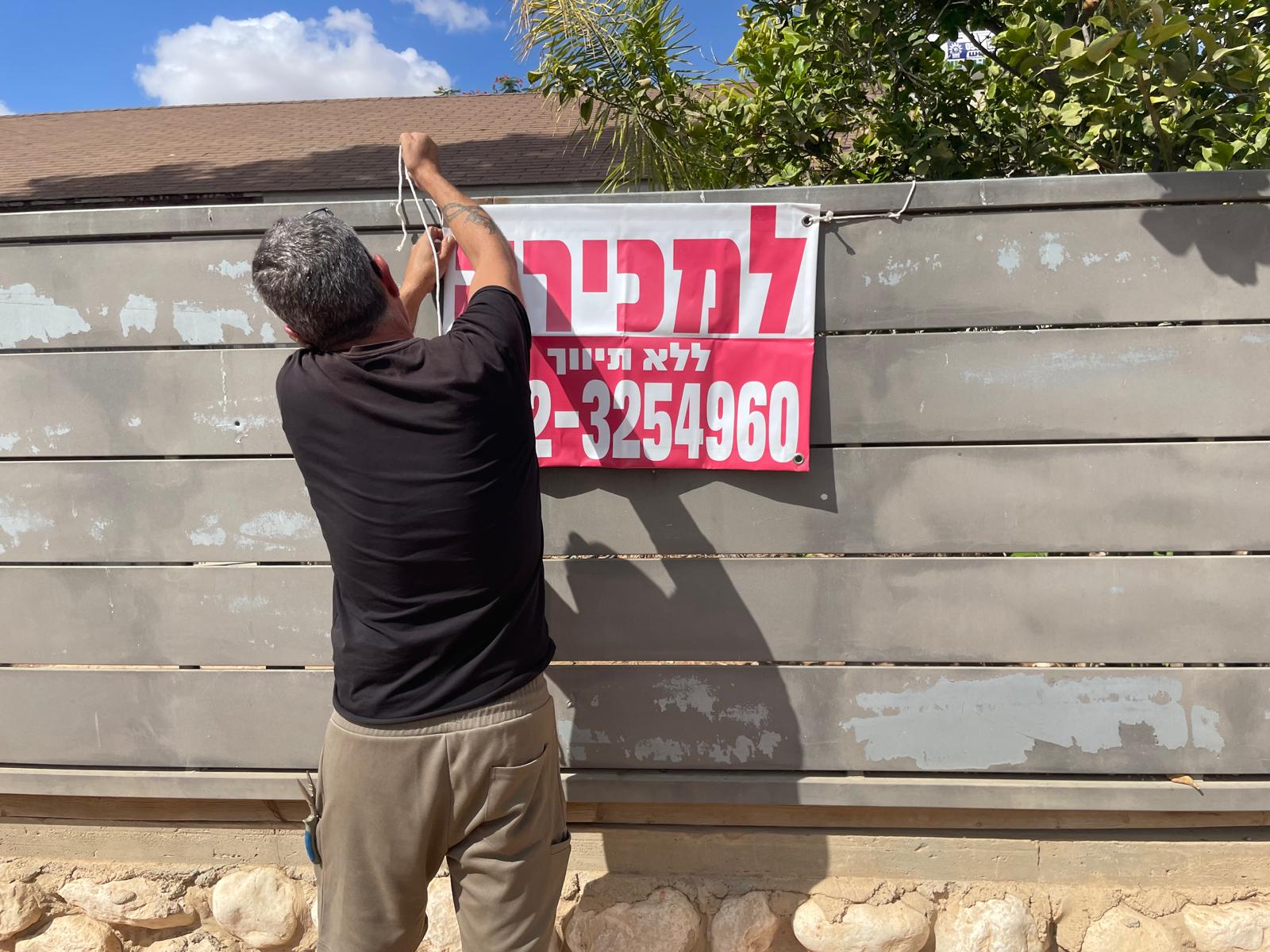 אלי אדרי תולה שלט "למכירה" על ביתו באופקים (צילום: יאנה פבזנר)