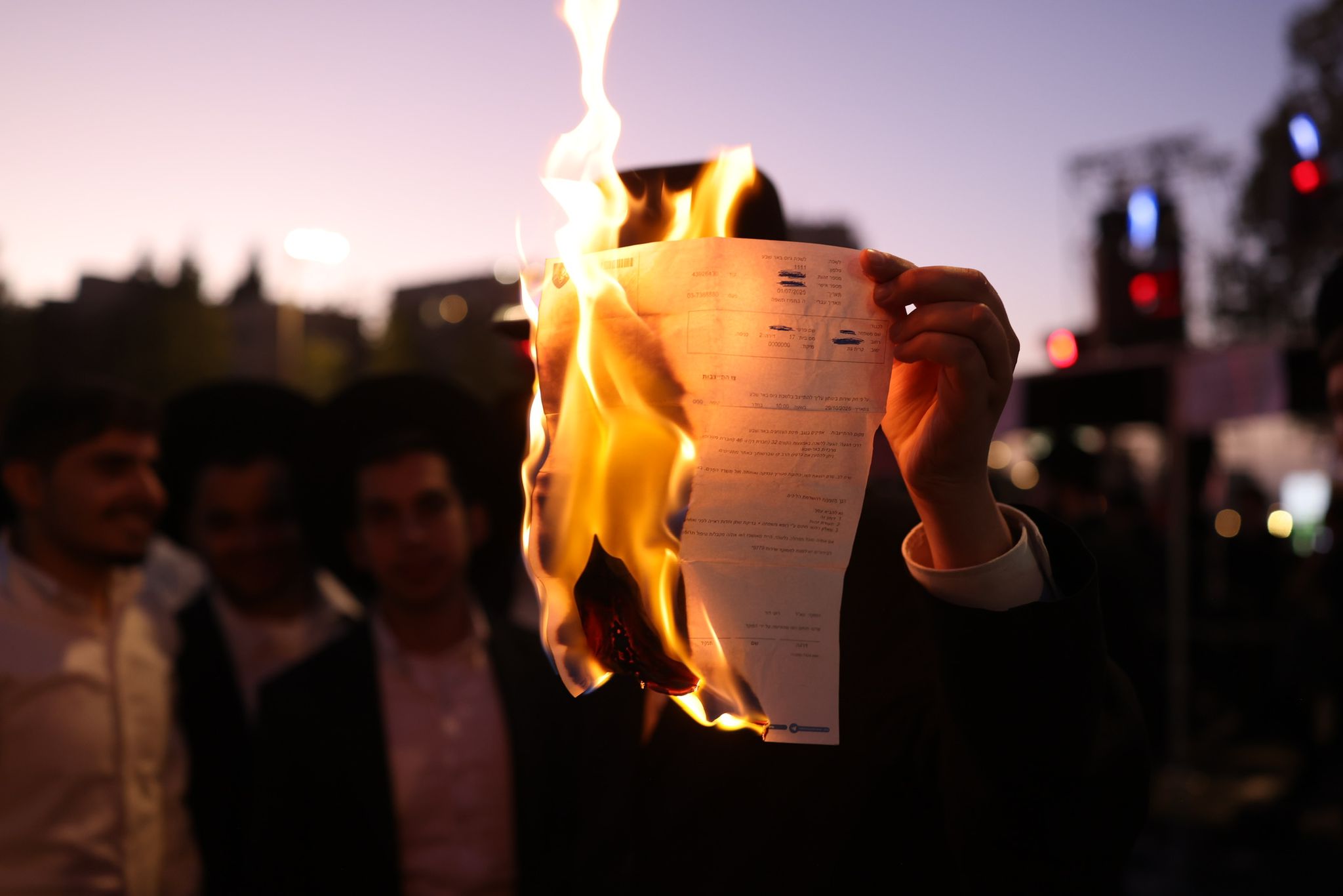 ההנהגה החרדית יודעת כמה פשתה מכת הציונות והמיליטריזם אצל הנוער שלהם. חרדי שורף צו גיוס במחאה בירושלים, 29 באוקטובר 2025 (צילום: אורן זיו)
