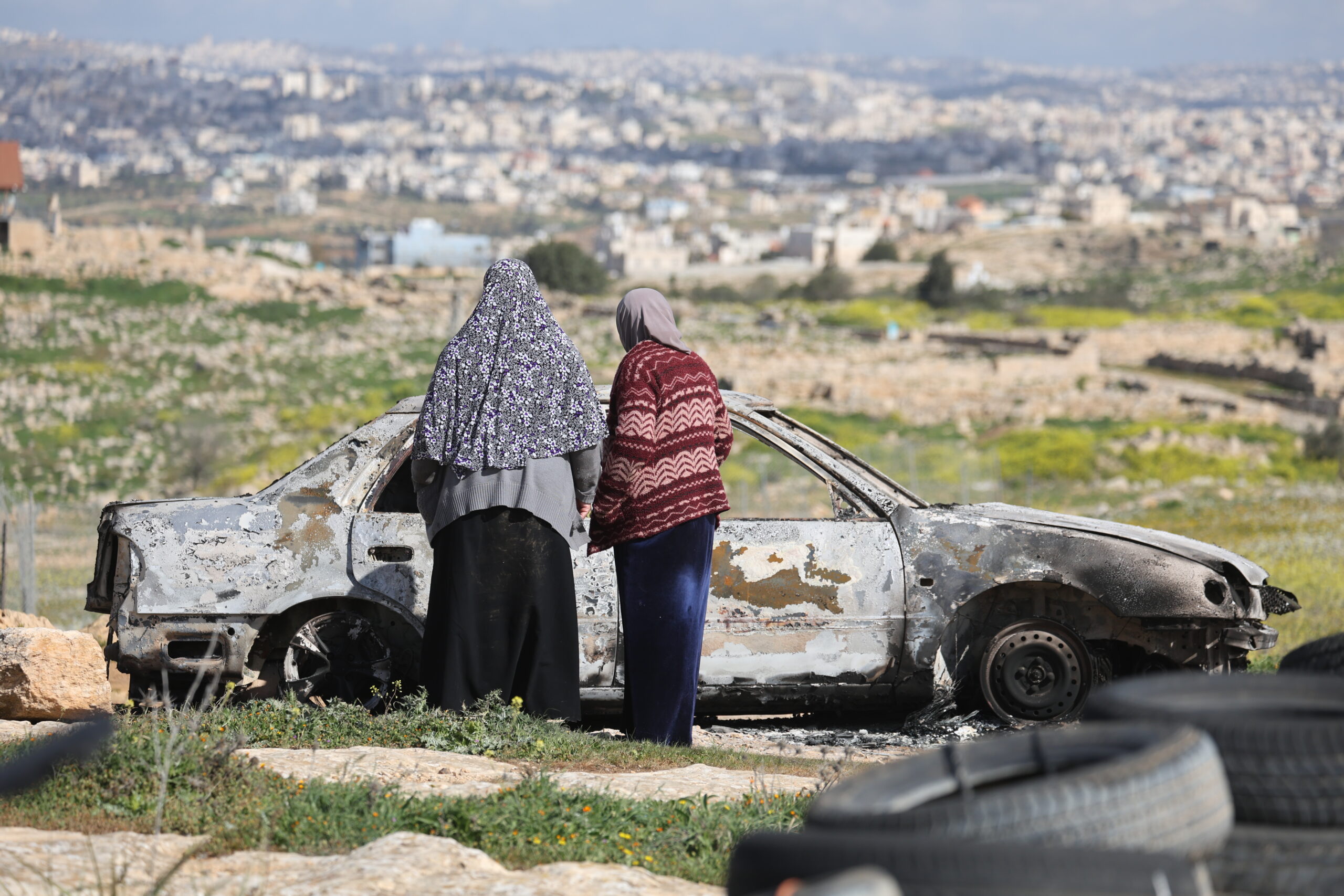 תושבות מסתכלות על רכב שהוצת על ידי מתנחלים בסוסיא (צילום: מסעב שאוור / אקטיבסטילס)